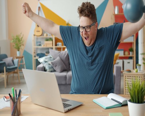A person stretching their arms while taking a break at their home office desk