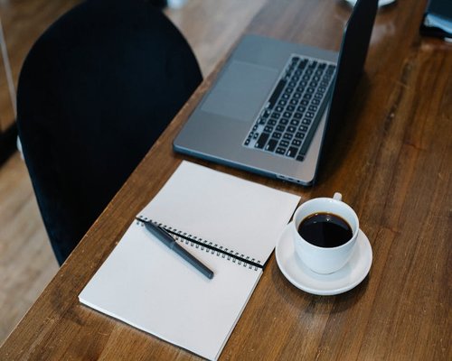 Coffee cup and notebook on a desk symbolizing a micro break